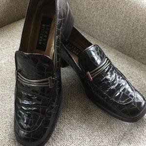 Stuart Weitzman brown crocodile-like loafers.
